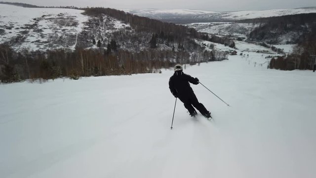 Skier enjoys idyllic perfect weather on winter day for recreation skiing down the fresh groomed piste