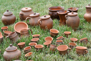 Fototapeta premium Lots of traditional ukrainian handmade clay pottery production on the green grass