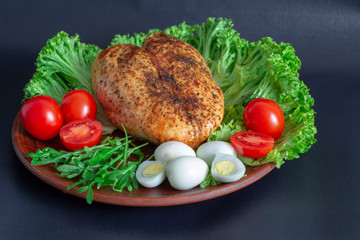 chicken breast on lettuce leaves with tomatoes and quail eggs