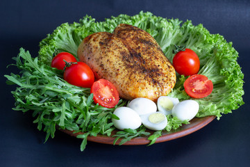 chicken breast on lettuce leaves with tomatoes and quail eggs