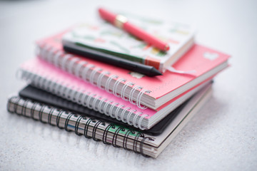 pink notebooks are spiral-bound in a pile on the table