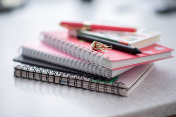 pink notebooks are spiral-bound in a pile on the table