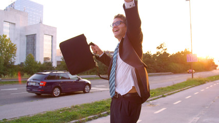 LENS FLARE: Playful yuppie celebrating a job promotion while walking home.