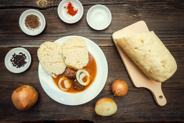 Goulash with Dumplings and Raw Cooking Ingredients on Wooden Background. Czech Republic Homemade Cuisine.
