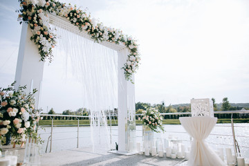 Wedding set up, outdoor wedding reception with arch  on the shore of the lake