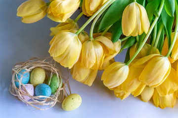 Easter background with yellow tulips and painted eggs. Traditional Christian Easter symbols.