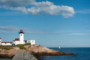 Fototapeta na wymiar Stone Breakwater by Eastern Point Lighthouse in Massachusetts