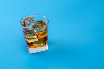 Alcohol in a glass with pastel blue background