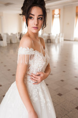 Portrait of a beautiful bride woman in elegant white wedding dress. Luxurious apartments. 