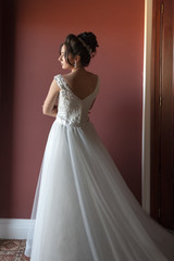 Fototapeta premium Portrait of a beautiful bride woman in elegant white wedding dress. Luxurious apartments. 