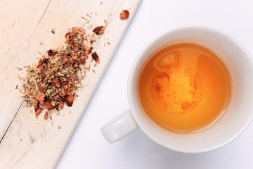 Top View Herbal Tea on White Background with Herbs on Wooden Table