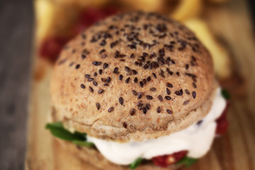 Homemade hamburger with wholemeal bread, on wooden background. Rustic burger. Close up