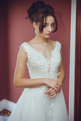 Portrait of a beautiful bride woman in elegant white wedding dress. Luxurious apartments. 