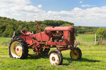 Fototapeta na wymiar Vintage red tractor in landscape