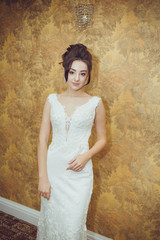 Portrait of a beautiful bride woman in elegant white wedding dress. Luxurious apartments. 