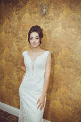 Portrait of a beautiful bride woman in elegant white wedding dress. Luxurious apartments. 