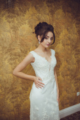 Portrait of a beautiful bride woman in elegant white wedding dress. Luxurious apartments. 