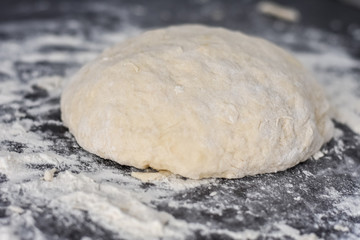 Fototapeta na wymiar dough on a black table, homemade food