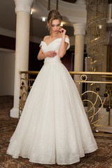 Naklejka premium Portrait of a beautiful bride woman in elegant white wedding dress. Luxurious apartments. 