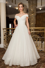 Fototapeta premium Portrait of a beautiful bride woman in elegant white wedding dress. Luxurious apartments. 