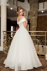 Naklejka premium Portrait of a beautiful bride woman in elegant white wedding dress. Luxurious apartments. 
