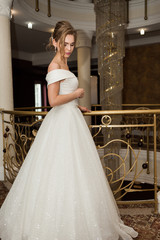 Naklejka premium Portrait of a beautiful bride woman in elegant white wedding dress. Luxurious apartments. 