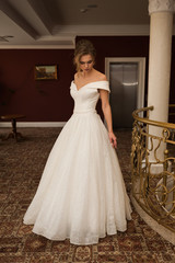 Naklejka premium Portrait of a beautiful bride woman in elegant white wedding dress. Luxurious apartments. 