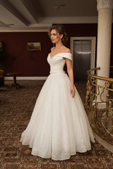 Portrait of a beautiful bride woman in elegant white wedding dress. Luxurious apartments. 