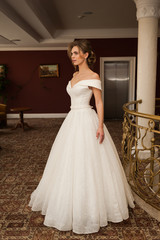 Fototapeta premium Portrait of a beautiful bride woman in elegant white wedding dress. Luxurious apartments. 
