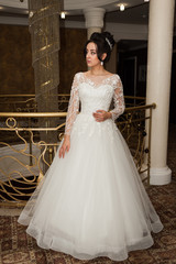 Fototapeta premium Beauty portrait of bride wearing fashion wedding dress with feathers with luxury delight make-up and hairstyle studio indoor photo.