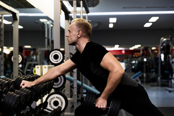 Young man doing the exercises with dumbbell at biceps for good body in fitness gym, bodybuilder, healthy lifestyle, exercise fitness, workout and sport training concept