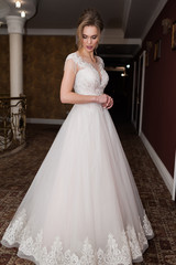 Fototapeta premium Beauty portrait of bride wearing fashion wedding dress with feathers with luxury delight make-up and hairstyle studio indoor photo.