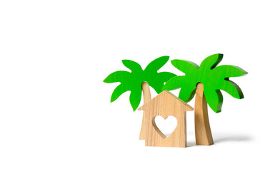 Fototapeta na wymiar Wooden palm tree and house with hearts on an isolated background. Rental homes and properties in the resort. Romantic travel. Entertainment and relaxation. Conceptual leisure and vacation.