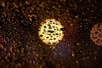 Colored drops on a glass at night