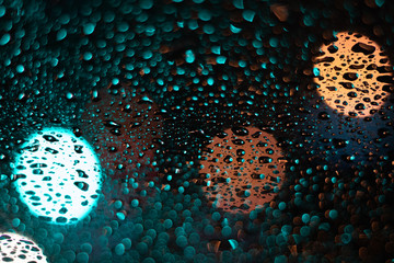 Colored drops on a glass at night