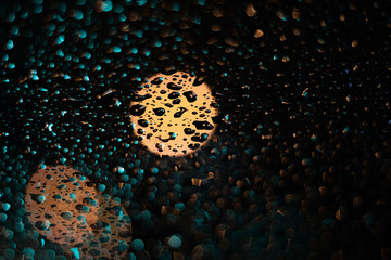 Colored drops on a glass at night