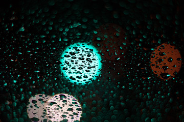 Colored drops on a glass at night