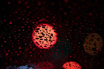 Colored drops on a glass at night