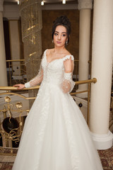 Naklejka premium beautiful bride in chic dress. delicate bride with long hair. girl in lace dress with loop in studio Bride%27s morning in a stylish interior