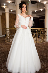 Obraz premium beautiful bride in chic dress. delicate bride with long hair. girl in lace dress with loop in studio Bride%27s morning in a stylish interior