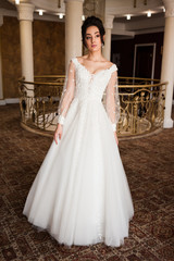 Obraz premium beautiful bride in chic dress. delicate bride with long hair. girl in lace dress with loop in studio Bride%27s morning in a stylish interior