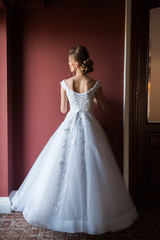 Fototapeta premium Morning of the bride when she wears a beautiful dress woman getting ready before wedding ceremony 