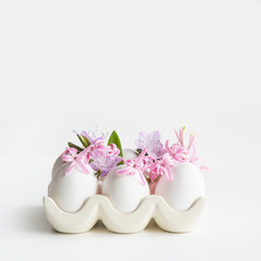 Organic white chicken eggs with flowers in porcelain box. Easter. Close up with copy space.