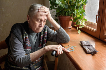 Portrait of an old woman counting money, rubles. The concept of old age, poverty, austerity.