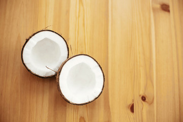 Halved coconut on wooden table, flat lay. Hello summer vacation concept. Space for text. Tropical background with coconut. Delicious nut, refreshing drink and oil source, tasty milk
