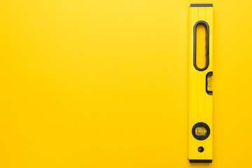 yellow spirit level on the yellow background with some copy space