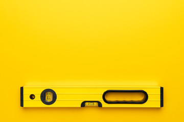 yellow spirit level on the yellow background with some copy space