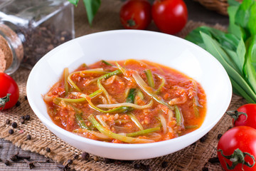 Ramson or wild garlic leaves in tomato sauce in a plate