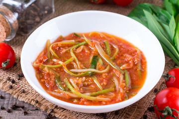 Ramson or wild garlic leaves in tomato sauce in a plate