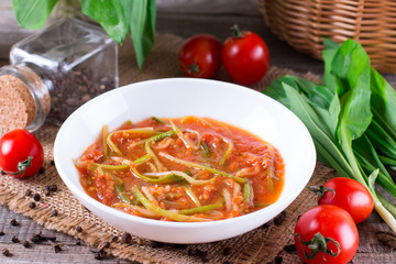Ramson or wild garlic leaves in tomato sauce in a plate
